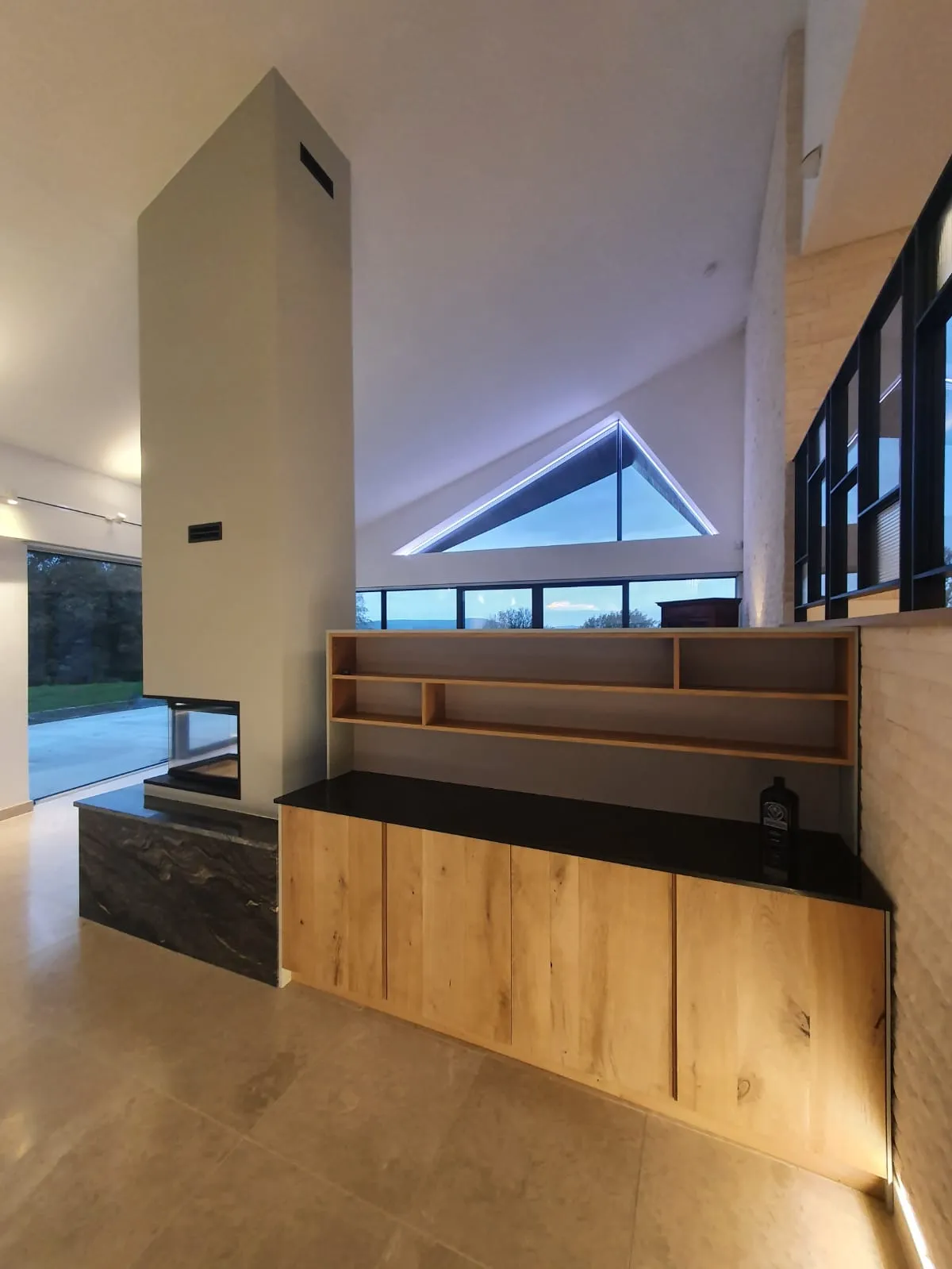 a room with a large window and a wooden bench