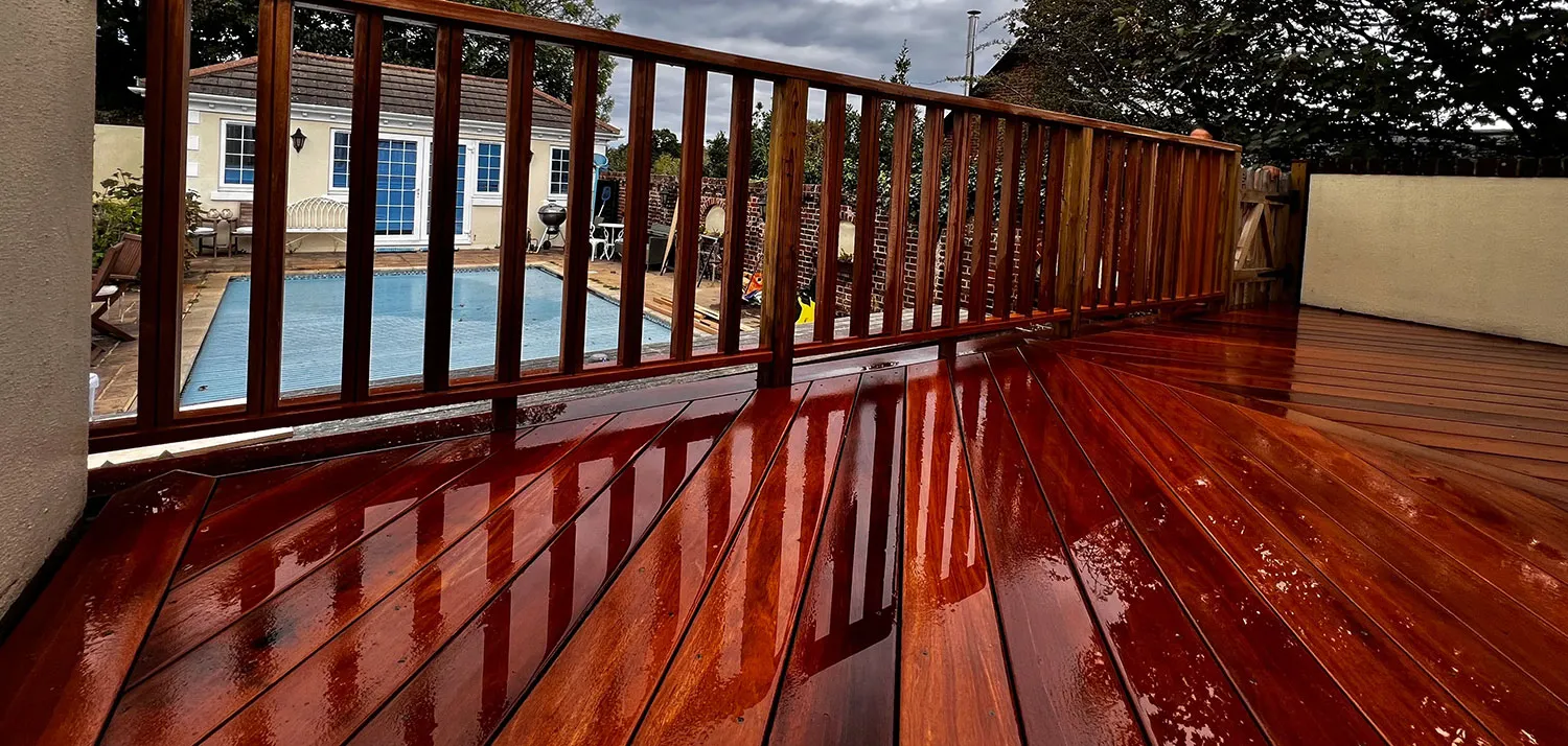 a wooden deck with a pool in the background