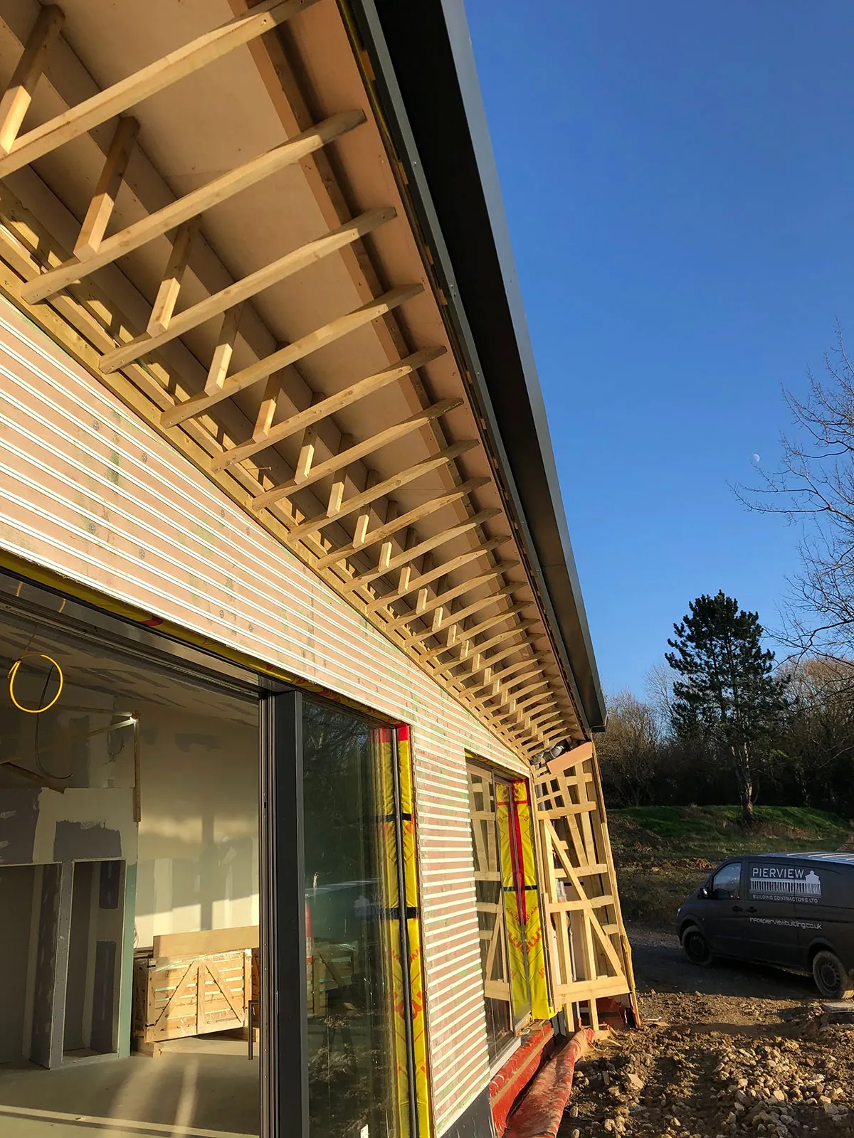 a house with a wooden roof and a car parked in front of it