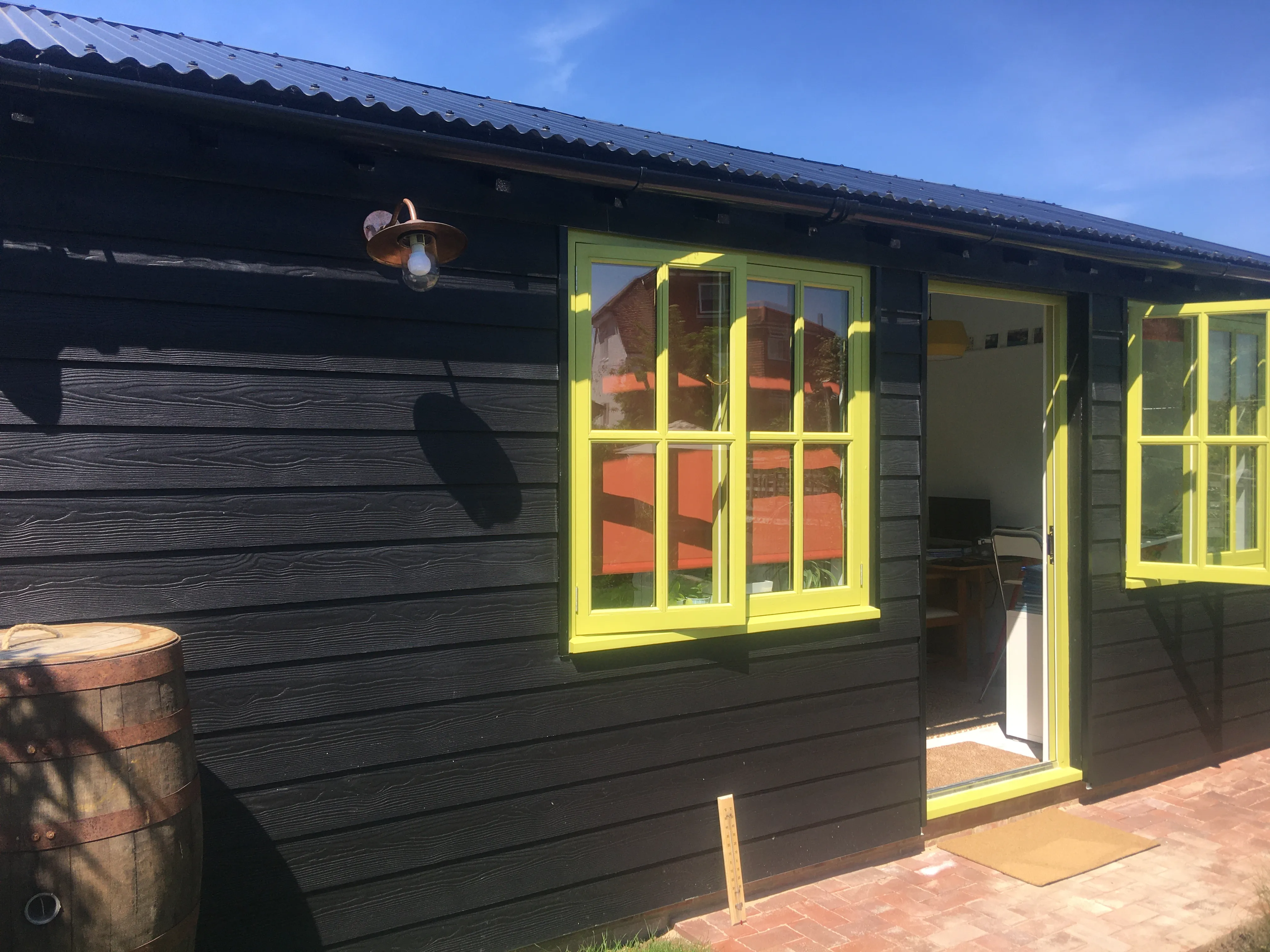 a black house with yellow windows and a brick walkway