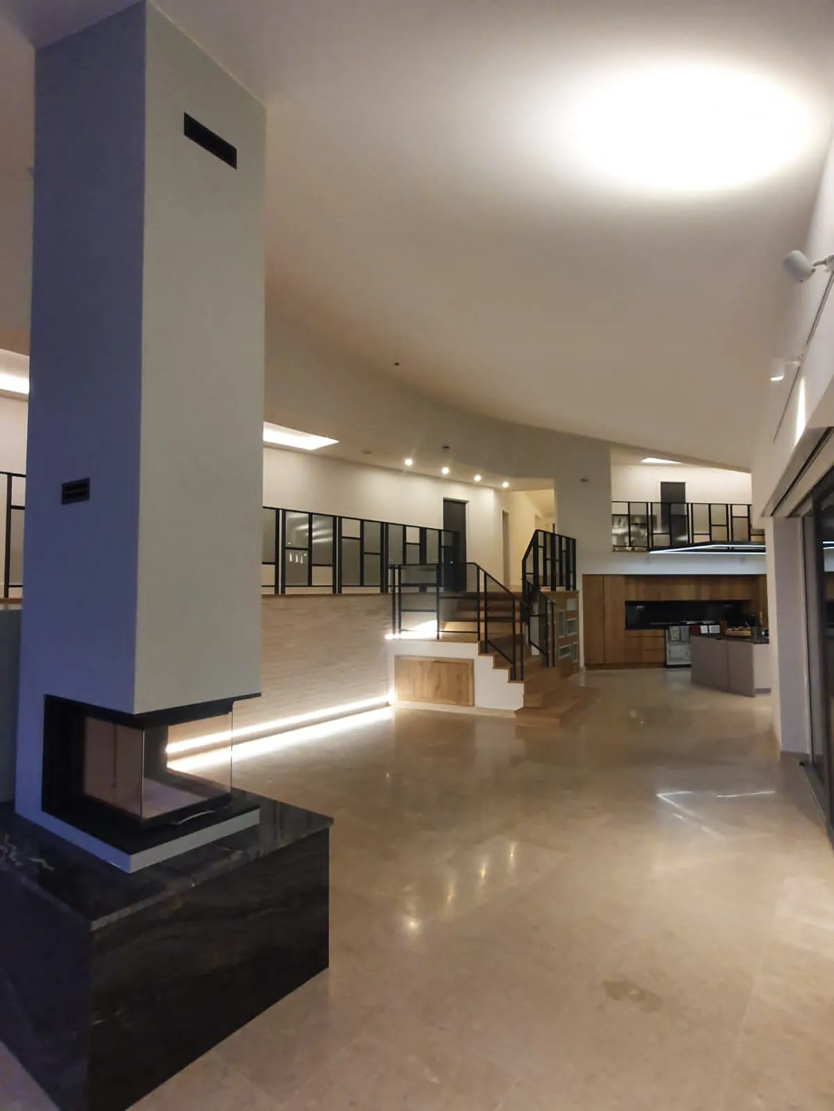 a large open space with a fireplace and stairs