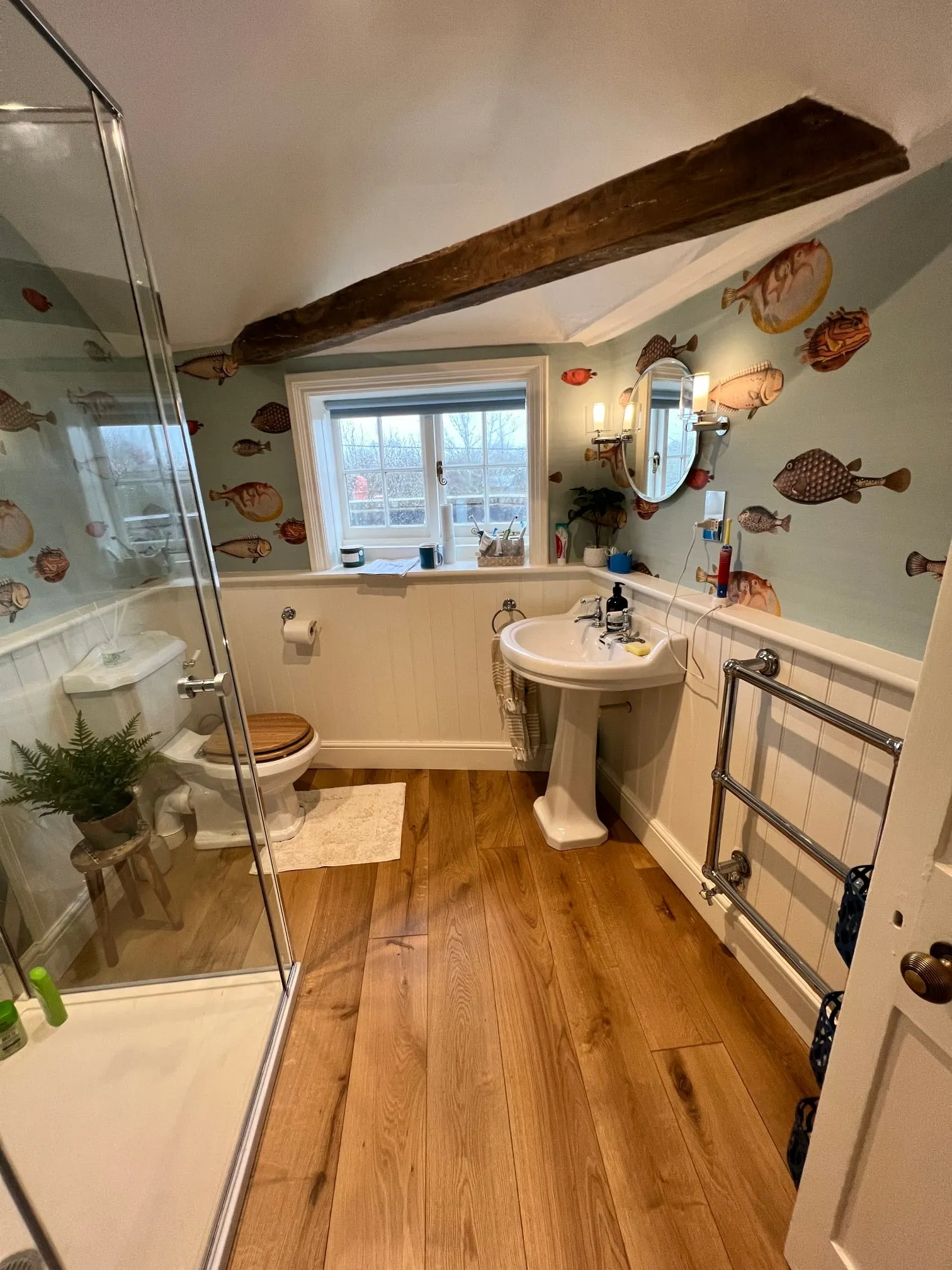 a bathroom with a wooden floor and white walls